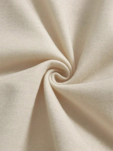 Close-up of premium beige knitted fabric showing soft texture and delicate fiber detail