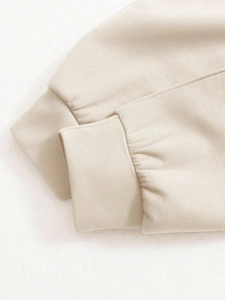 Close-up of ribbed cuffs on beige long sleeve sweatshirt showing quality stitching