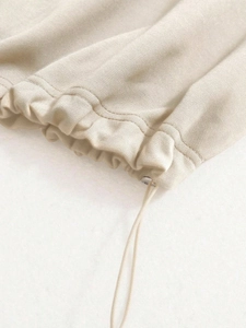 Detail shot of beige sweatshirt cuff with drawstring and silver metal eyelets texture