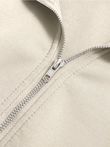 Detailed macro view of silver metal zipper and beige diagonal twill fabric texture
