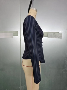 Detailed side view of navy blue pinstripe blazer featuring tailored waist and pleats