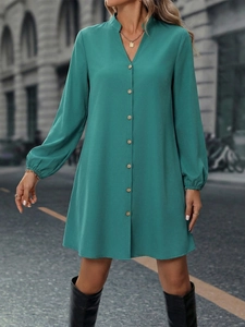 Detail of teal long-sleeve dress featuring wooden buttons and elegant V-neck design
