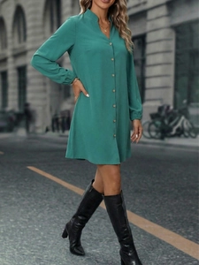 Detail of teal long sleeve shirt dress featuring classic stand collar and wooden buttons