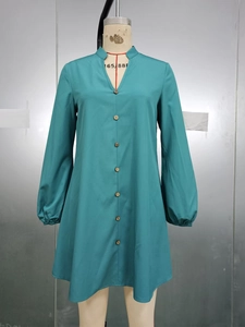 Detail of teal long sleeve dress with V-neckline and row of wooden buttons down the front