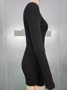 Détail de la couture froncée et texture en maille côtelée sur une robe noire moulante chic