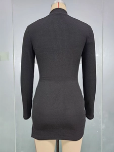 Gros plan sur la maille côtelée et la couture arrière d'une robe noire ajustée à manches longues
