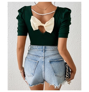 Detail of slim-fit backless top with a large white bow on back and denim shorts