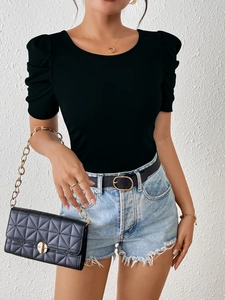 Close-up of black crew neck top with stylish puff sleeves and premium ribbed fabric texture