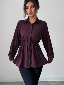 Détail d'un chemisier violet à manches longues avec taille ajustable et col à revers