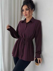Détail de la taille ajustable avec cordon et tissu violet drapé sur chemise à manches longues