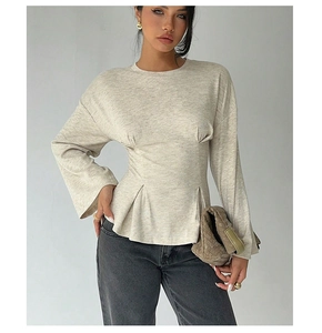 Detail of the oatmeal long sleeve knit top with ruched waist and bell sleeve design