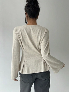 Women's light beige flared long sleeve top with peplum waist and knitted texture