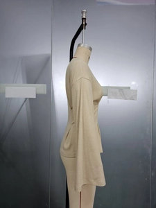 Detail of light beige long sleeve top featuring ribbed texture and elegant flared sleeves