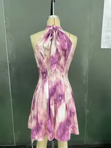 Dettaglio dell'abito halter tie-dye viola e bianco con un grande fiocco sulla schiena