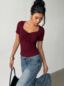 Close-up of wine red slim top with lace square neck, bow detail and ribbed texture
