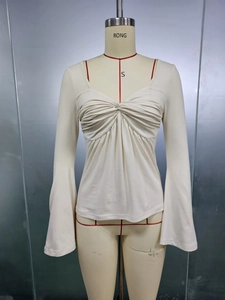 Detail of V-neck top showing front twist knot and pleated texture on long bell sleeves