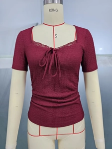 Detailed close-up of smocked burgundy top featuring sweetheart lace neckline and bow