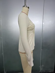 Detail of beige long-sleeve top featuring ruched chest design and soft elastic fabric