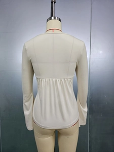 Detail of slim fit beige long sleeve top featuring a high waist back drawstring design