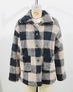 Detail of soft fleece fabric texture on a plaid oversized winter cardigan with buttons