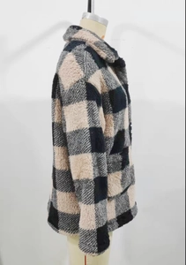 Detail of checkered plush coat featuring thick plaid faux fur and classic lapel design