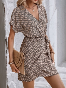 Détail d'une robe fleurie cache-cœur à col en V avec ceinture et motif chaîne