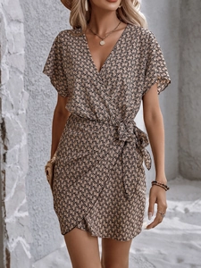 Détail de robe cache-cœur col en V avec imprimé chaîne kaki et lien à la taille