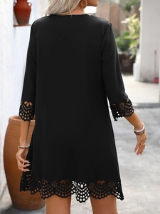 Detailed back view of a black A-line dress featuring laser-cut floral eyelet embroidery