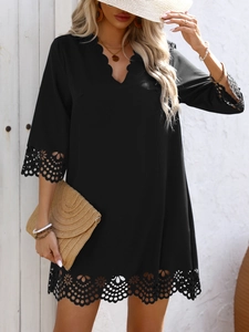 Detail of V-neckline and intricate floral cutout embroidery on black summer vacation dress