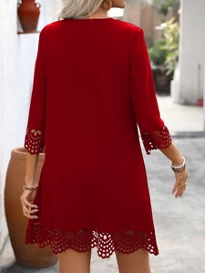 Detailed view of the intricate laser-cut floral patterns on the hem of a red A-line dress