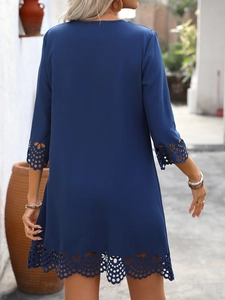 Detailed view of the laser-cut hollow petal pattern on the hem of a dark blue dress