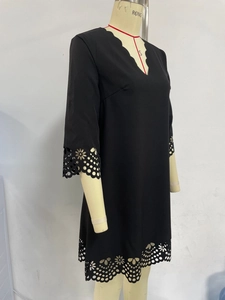 Detailed laser-cut hollowed-out wave patterns on the black dress sleeves and hem