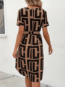 Detail van de bruine jurk met geometrische print, korte mouwen en bijpassende ceintuur