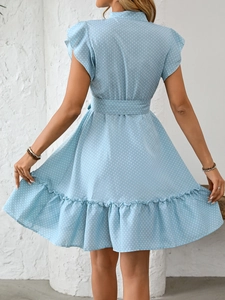 Détail du dos de la robe bleu clair à pois avec ourlet à volants et lien à la taille