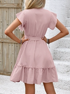 Détail de la robe rose à pois montrant les manches à volants et la taille nouée