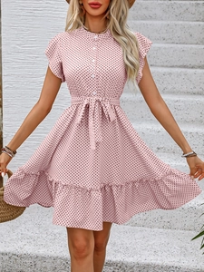 Détail d'une robe rose à pois avec manches à volants, lien taille et col boutonné