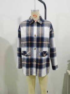 Detail view of the vintage plaid jacket showing front flap pockets and classic shirt collar