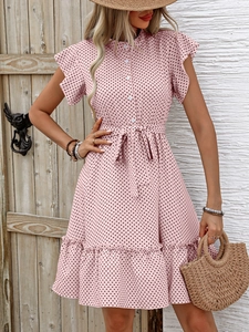 Détail d'une robe rose à pois montrant les manches à volants et le lien de serrage à la taille