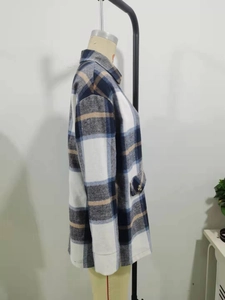 Detail of blue and khaki plaid jacket showing thick fabric texture and side pocket