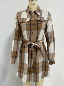 Detailed view of the brown plaid shirt dress featuring front pockets and waist tie