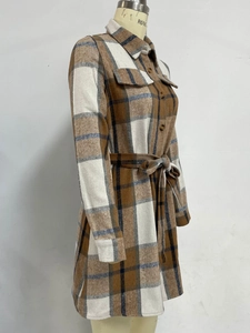 Detail of plaid long sleeve shirt dress featuring chest pockets and belted waist tie