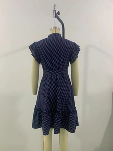 Vue détaillée de la robe bleu marine à pois montrant les manches et l'ourlet volantés
