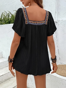 Detail of bohemian black square neck top with colorful geometric embroidery and ruffle sleeves