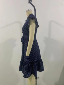 Détail d'une robe à pois bleu marine avec manches à volants et lien de serrage à la taille