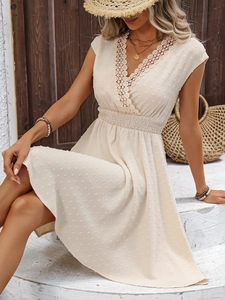 Close-up of Swiss dot fabric and delicate lace trim on the V-neckline of this beige dress