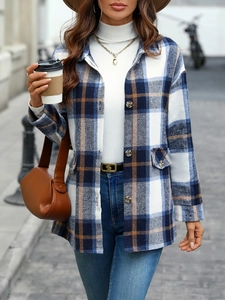 Close-up of blue and brown plaid shacket featuring flap chest pockets and metal buttons
