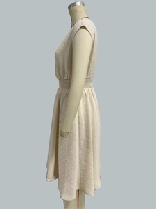 Detail view of Swiss dot textured fabric and elastic waist on sleeveless white dress