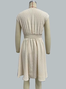 Detailed back view of beige Swiss dot dress showing waistline and A-line silhouette
