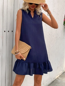 Detail of navy blue sleeveless A-line dress with tiered ruffle hem and textured fabric
