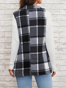 Rear view of an elegant black and white plaid vest with lapel collar over a white sweater